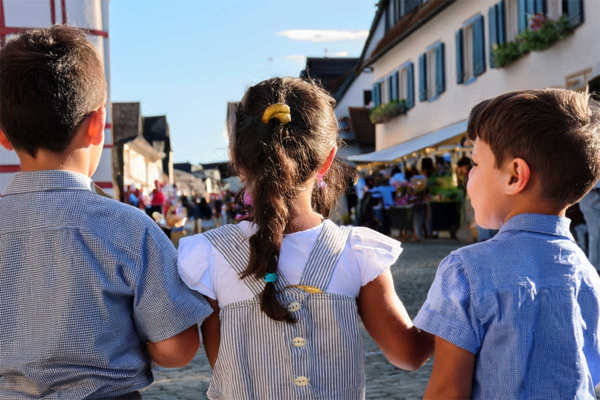 Ein Mädchen und zwei Bubn in einer bayerischen Gemeinde